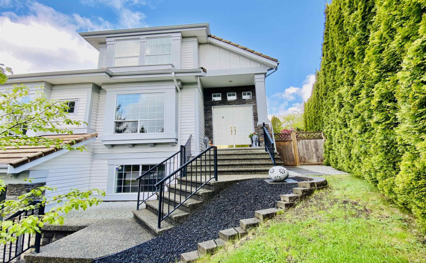 GRAND DOUBLE FRONT DOORS WITH BLACK LAVAL ROCKS LANDSCAPING / BLACK RAILINGS TO COMPLETE THE LUXURIOUS LOOKS.
