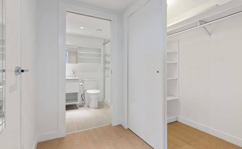 Walk in closet with shelving and a light too.