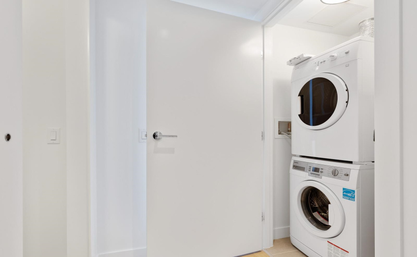 Laundry room with shelves and room for storage.
