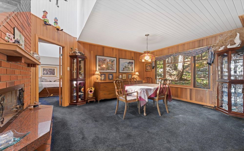 This large dining room is open to the living room and kitchen, but also enjoys a very private forest view.