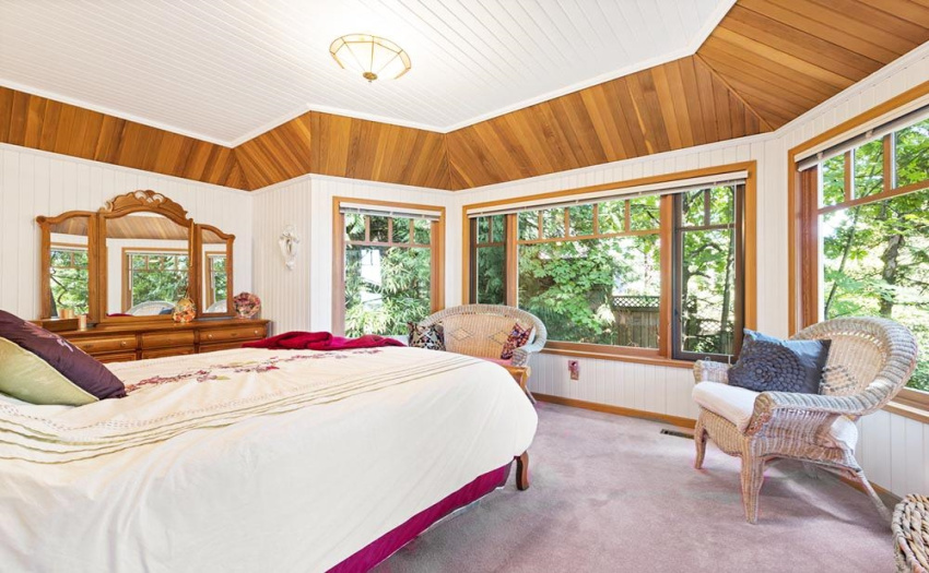 Even with its many windows the primary bedroom is completely private set among a stunning west coast forest outlook.