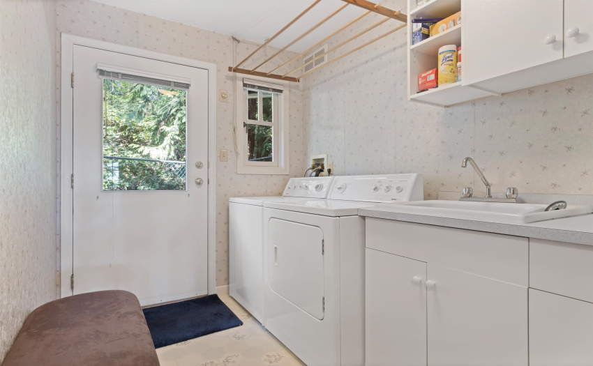 The laundry room is spacious and conveniently located off the kitchen.  This exterior door leads to a fenced yard area - a safe play area for your pet.