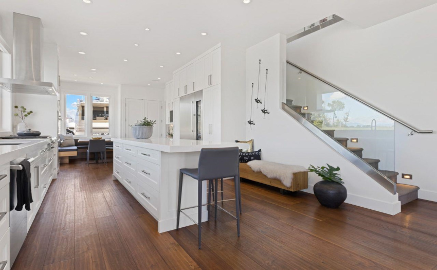 Quartz counters and white cabinetry with stainless appliances.  Expansive glass brings in the view of boats passing or wildlife on the water.