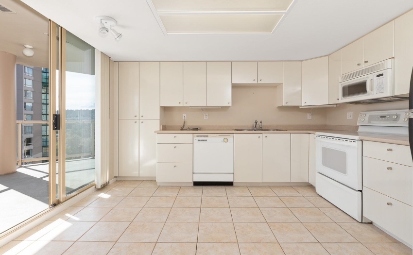 House size kitchen leads to fully covered deck.