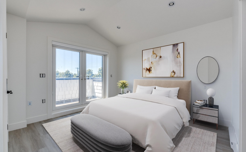 Private primary bedroom with vaulted ceilings, double sink ensuite and balcony showing views of the North Shore Mountains and western cityscape.