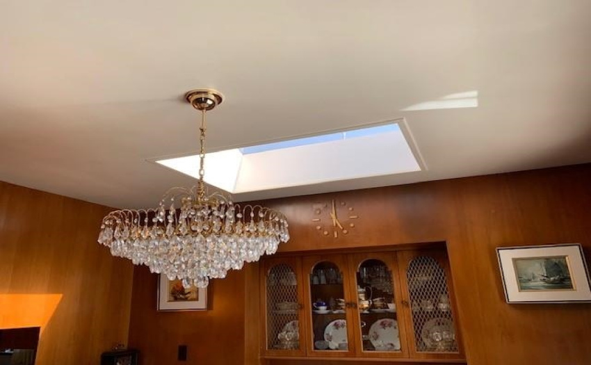 Dining room with skylights and custom made cabinets / wall paneling and clock by original owner.