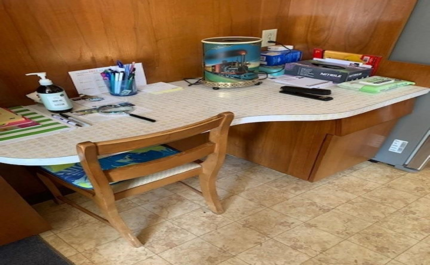 Phone desk in kitchen with drawer and cabinet.