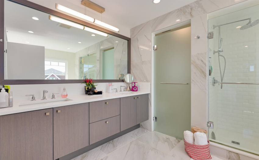 spa inspired ensuite bath features soaker bathtub, rain head shower, double vanities. glass- enclosed toilet room