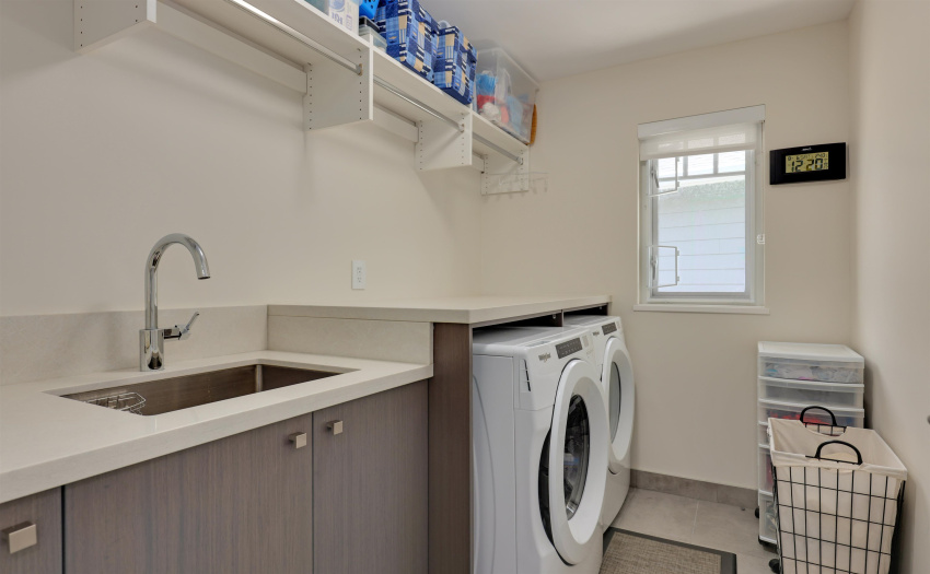 functional laundry room on upper floor featuring a sink,  quartz counter top, cabinets and super size top brand name washer and dryer