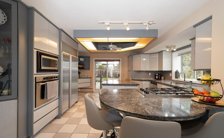 Kitchen with granite counters, gas stove, island and breakfast bar.