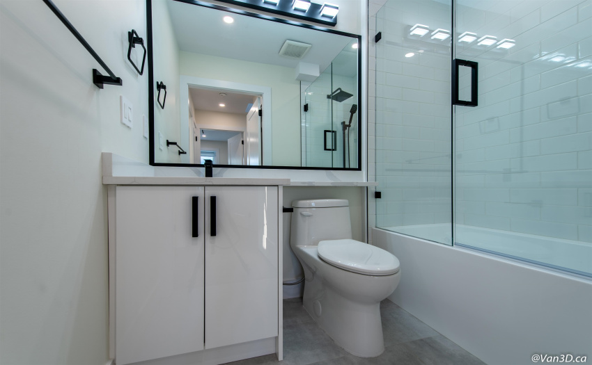 Full bathroom on main floor with high end finishings, stone countertops, and black hardware accents.