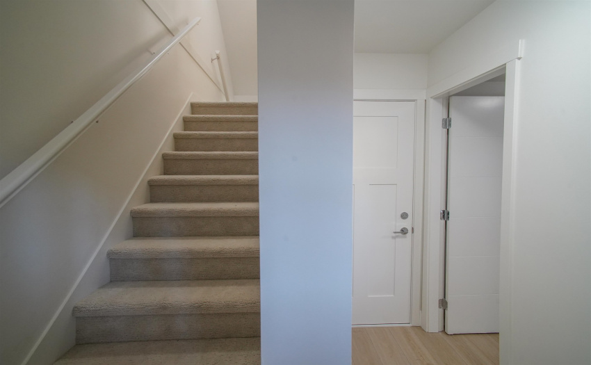 Carpeted stairs, as viewed when entering from the door with access to 72nd avenue. The right door in the picture leads to the bedroom, while the left one connects to the garage.