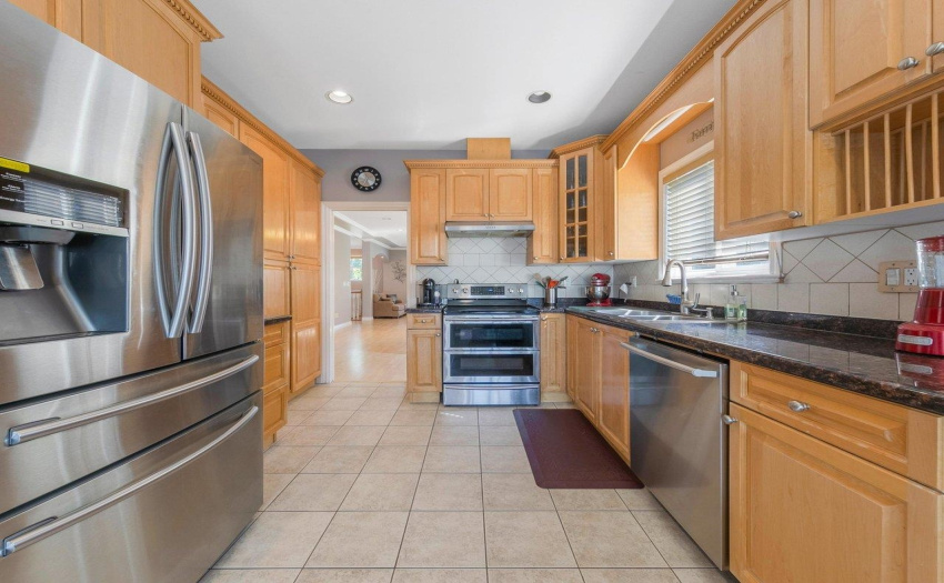 Large kitchen with eat-in area, granite countertops, and spacious covered deck