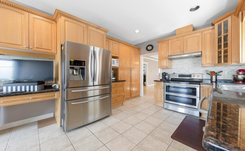 Large kitchen with eat-in area, granite countertops, and spacious covered deck