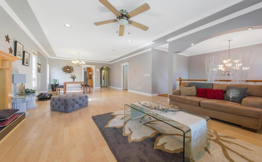 Huge open living room and dining area with tray ceilings and custom moulding