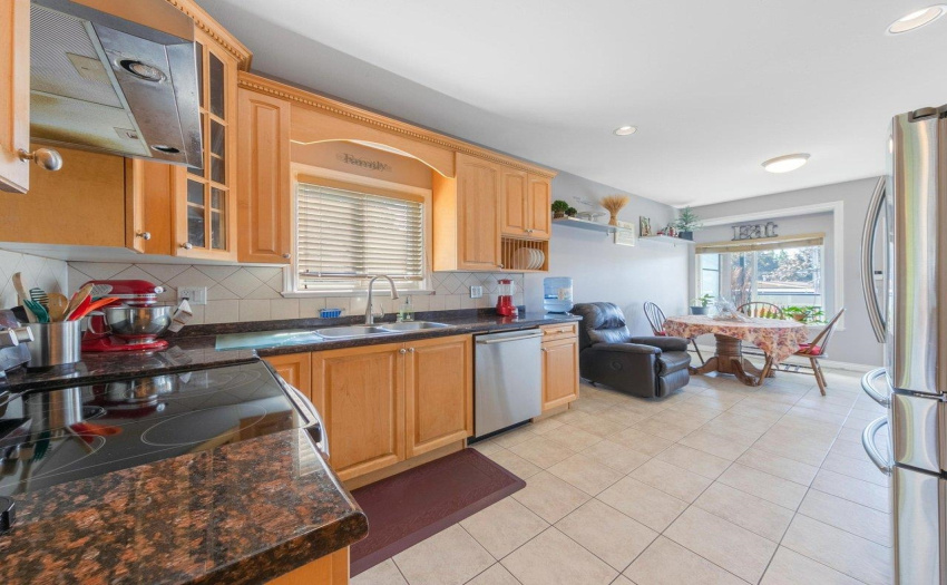 Large kitchen with eat-in area, granite countertops, and spacious covered deck