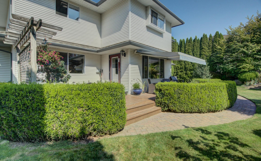 Off of the kitchen is a brick path that leads to a wooden patio.