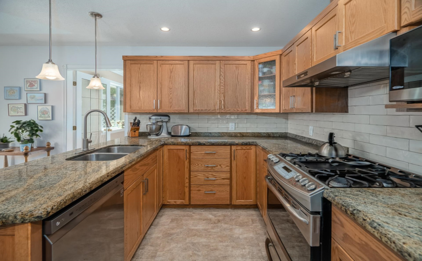 Updated with granite counters, tile backsplash, newer wood shaker cabinet/drawer fronts, gas stove make this a very functional working  kitchen.