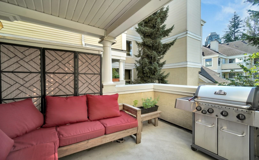 Covered private balcony overlooking green quiet courtyard.