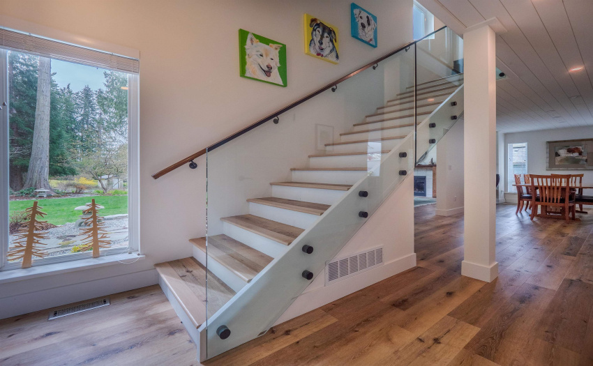 Glass and copper highlight the stairs to the upper floor.  There is a powder room just to the right of this photo for guests.