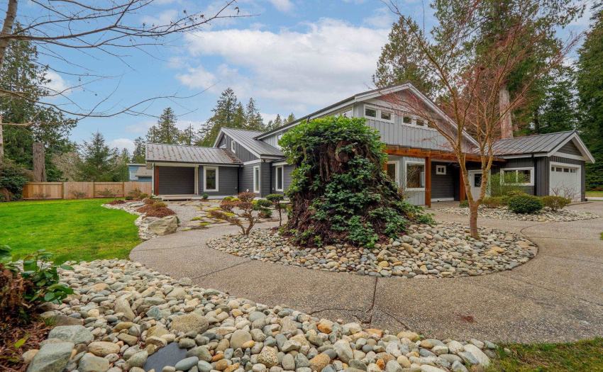 The driveway winds around to the side of the home through mature gardens, tall trees and walkways...a welcoming approach to this lovely oasis.