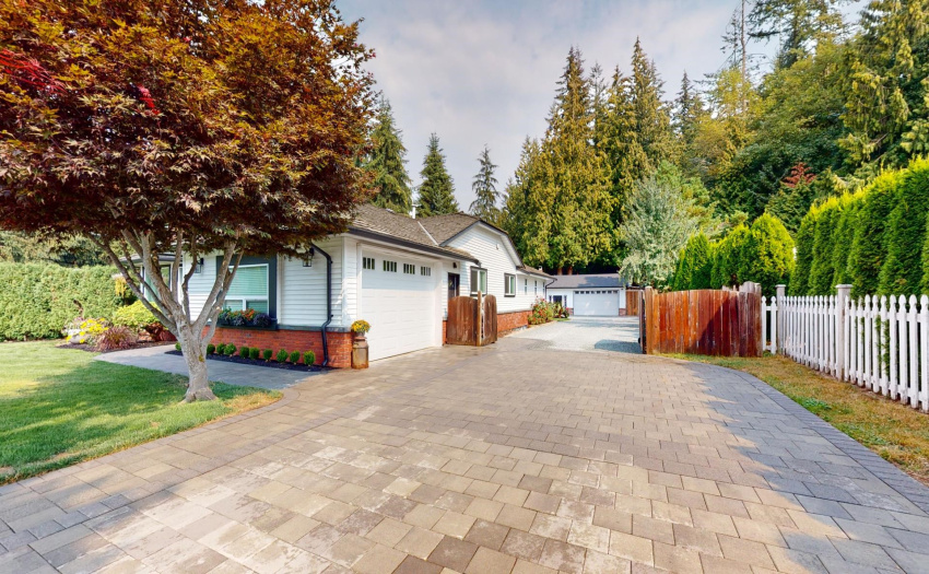 Massive Driveway tastefully done with pavers leading to an attached garage & 29 x 32 Rear garage/workshop w/ 220 power